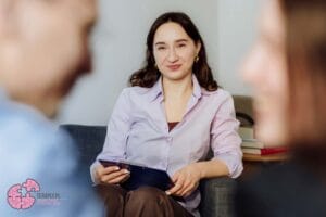 psycholog podczas sesji terapeutycznej w gabinecie w Katowicach, trzymająca podkładkę z dokumentami