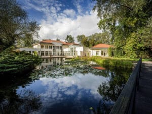 Luksusowy prywatny ośrodek leczenia uzależnień otoczony zielenią, z ogrodem i stawem